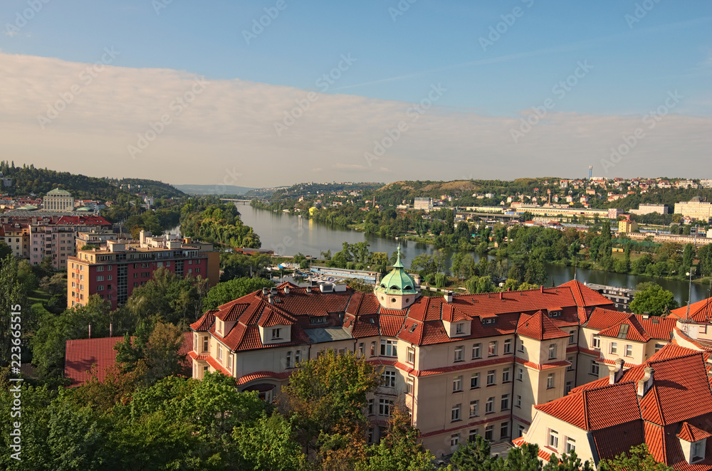 A picturesque view of residential buildings near the Vltava river. Summer landscape photo on a sunny morning. Prague, Czech Republic