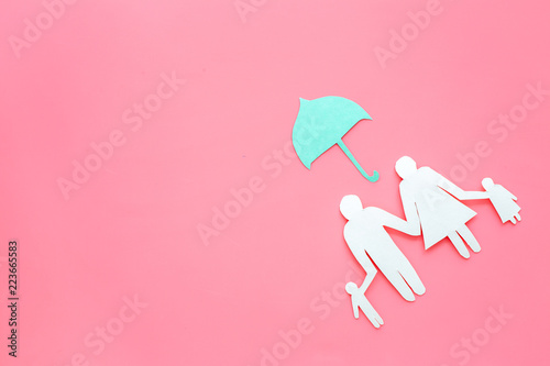Illustration of social security concept. Financial protection. Family silhouette, cutout under umbrella on pink background top view copy space photo