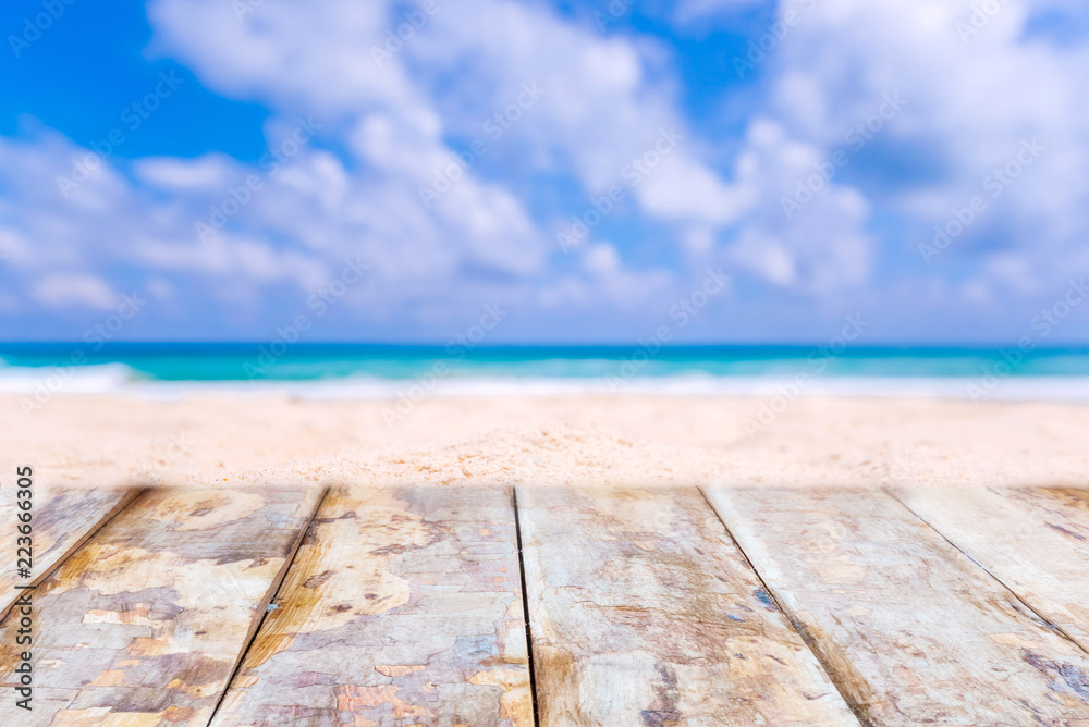 Fototapeta premium Wooden desk or plank on sand beach in summer. background. For product display