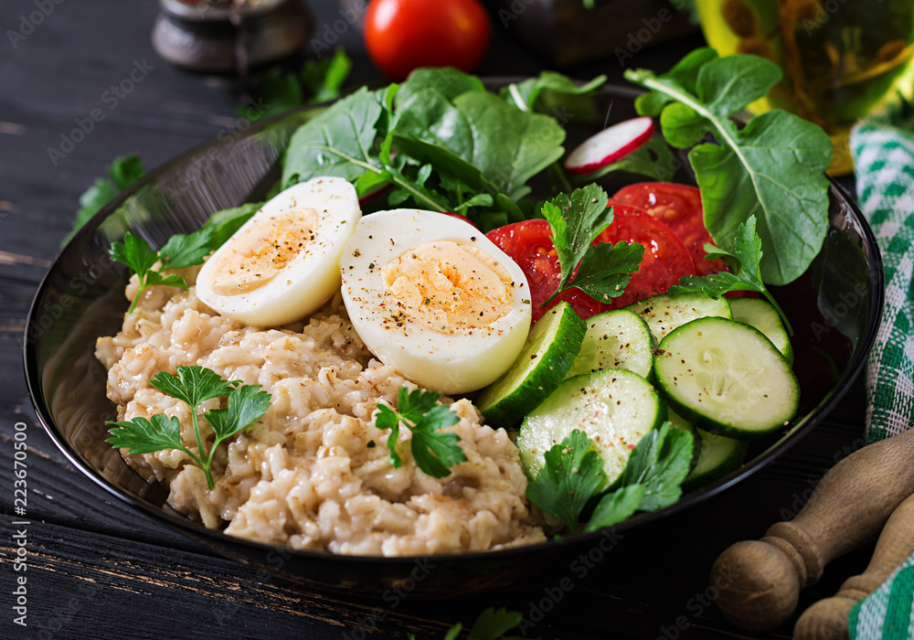 Healthy salad of fresh vegetables - tomatoes, cucumber, radish, egg, arugula and oatmeal on bowl. Diet food. Healthy salad of fresh vegetables - tomatoes, cucumber, radish, egg, arugula and oatmeal on bowl. Diet food.