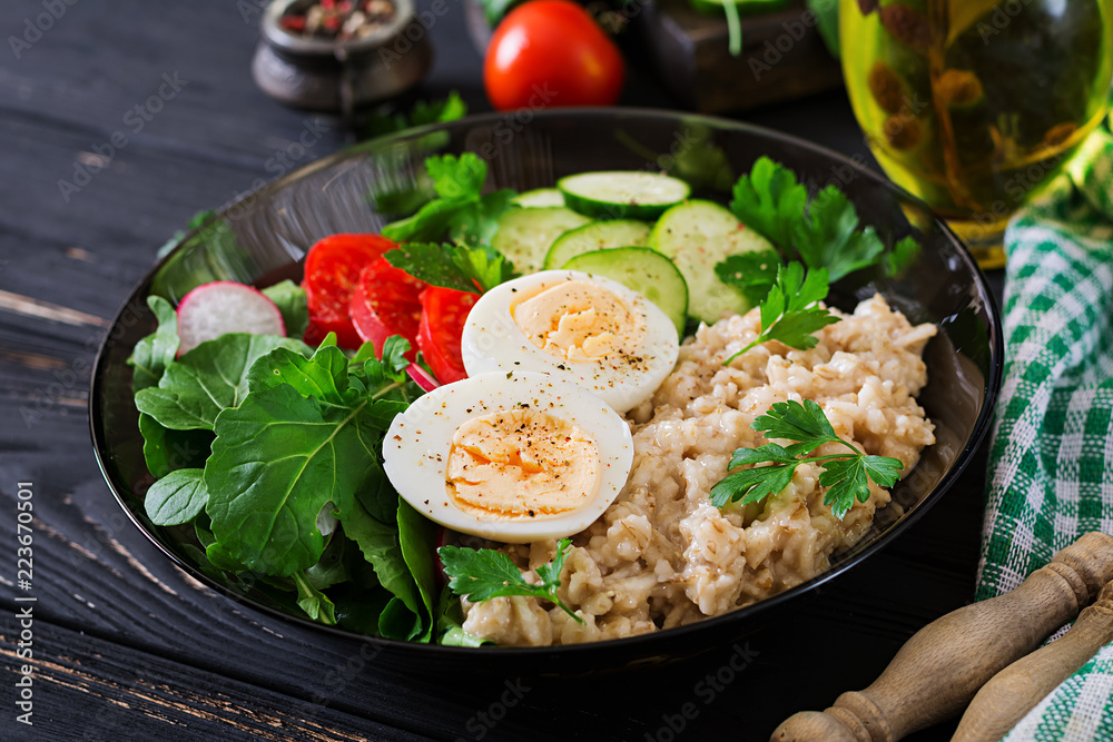 Healthy salad of fresh vegetables - tomatoes, cucumber, radish, egg, arugula and oatmeal on bowl. Diet food. Healthy salad of fresh vegetables - tomatoes, cucumber, radish, egg, arugula and oatmeal on bowl. Diet food.