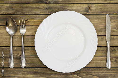 Empty dish and cutlery on wooden background closeup