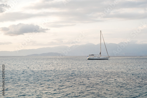 sea, mountains landscape, sailboat sailing far from seashore