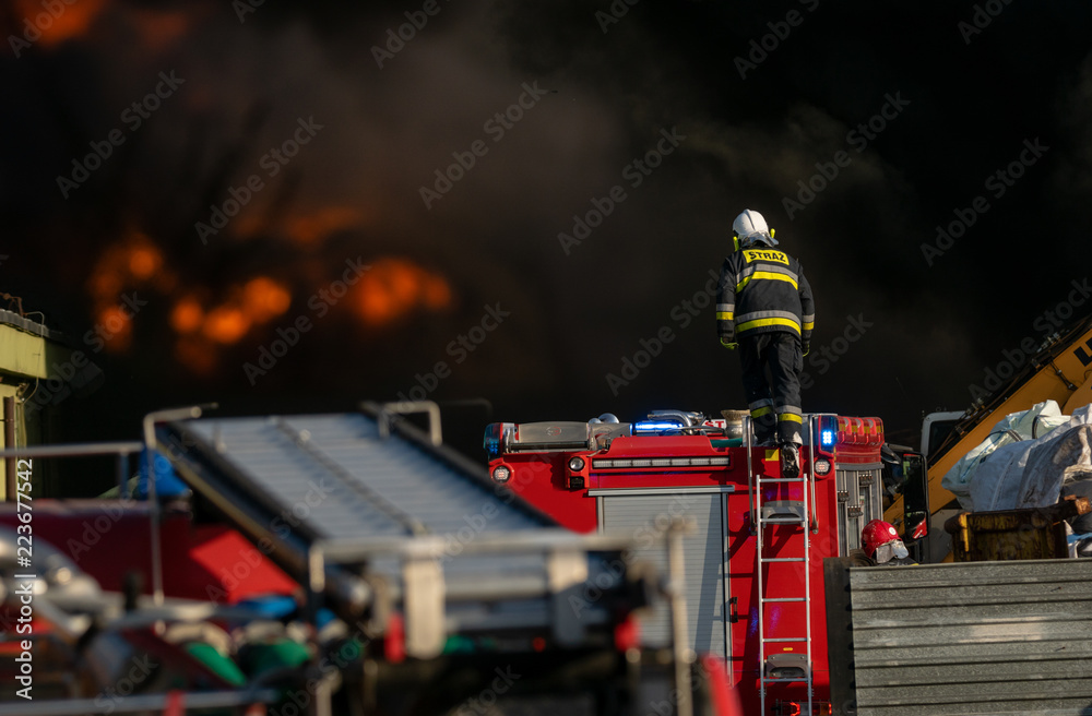 Naklejka premium firefighters during the action of extinguishing a powerful fire of a recycling company.Poland, Szczecin