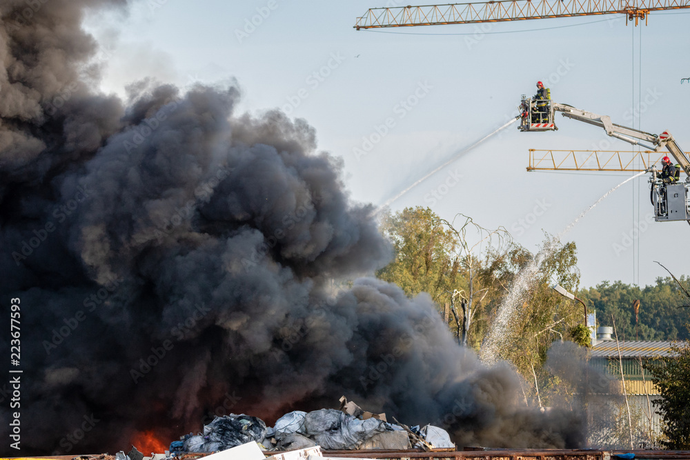 Obraz premium firefighters during the action of extinguishing a powerful fire of a recycling company.Poland, Szczecin