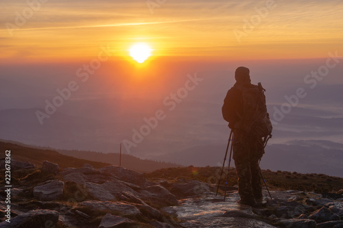 Photographer photographing the sunrise on the top of the mountain