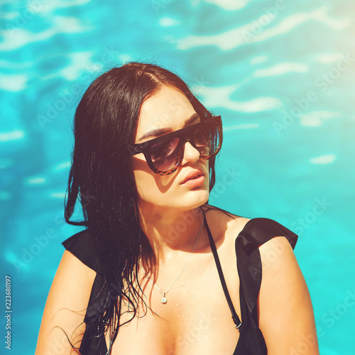 Amazing beautiful woman with big breast and black bikini at swimming pool at Bang Boet beach. Sexy hot wet girl in pool in sunglasses. Enjoy your vacation properly, best vacation in tropical places photo