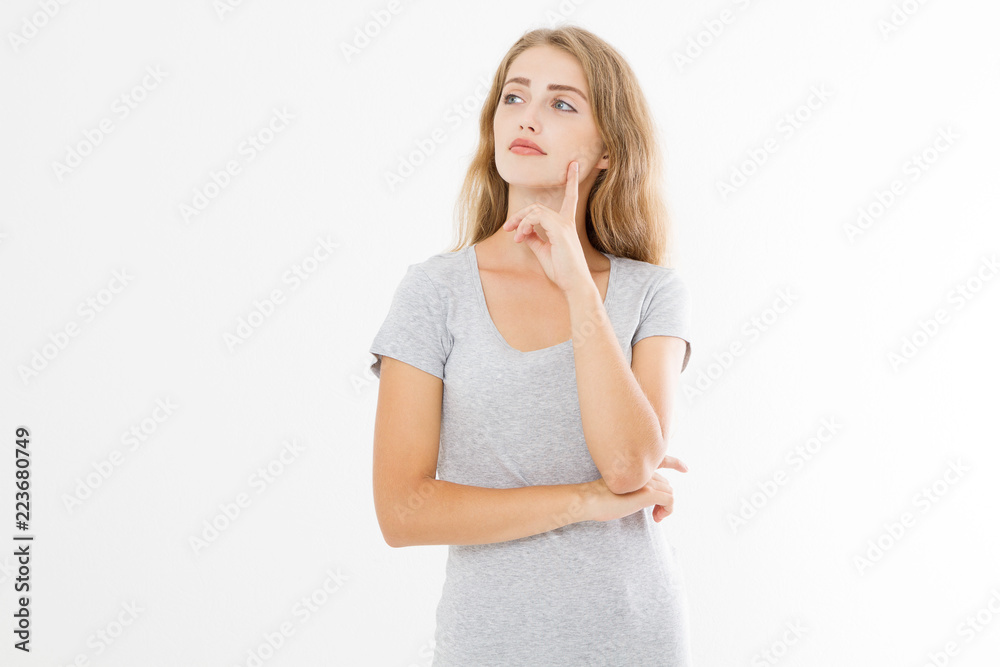 Thinking young blonde woman in blank template t shirt isolated on white background. Skin and hair care. Copy space and mock up Thinking young blonde woman in blank template t shirt isolated on white background. Skin and hair care. Copy space and mock up