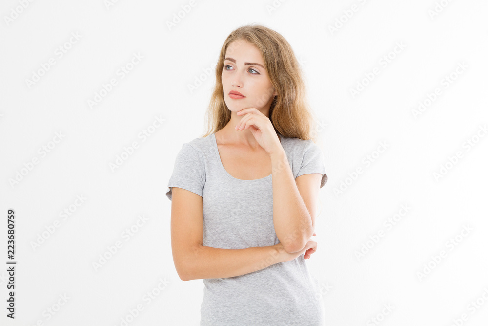 Thinking young blonde woman in blank template t shirt isolated on white background. Skin and hair care. Copy space and mock up Thinking young blonde woman in blank template t shirt isolated on white background. Skin and hair care. Copy space and mock up