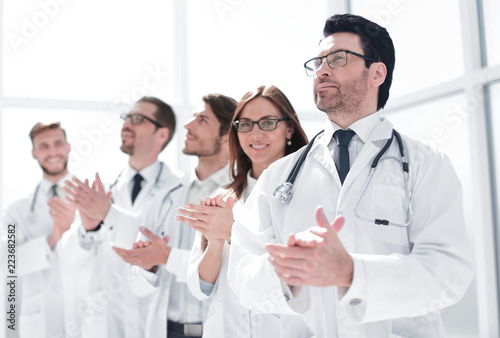 group of doctors applauds, standing in the hospital