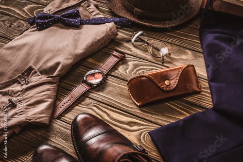 close up view of arrangement of masculine fashionable clothing and accessroies on wooden tabletop