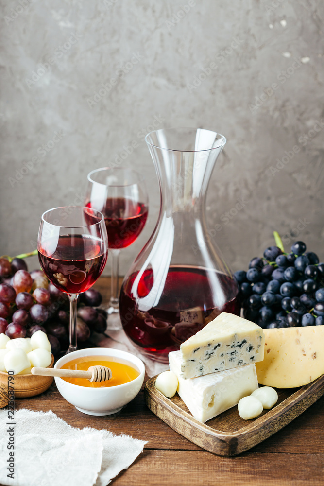 Cheese, wine and honey, wooden board, gray background, snack, alcohol, dairy products