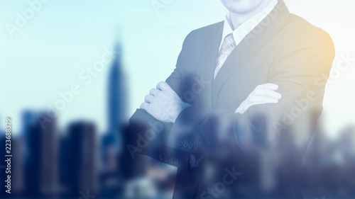 Businessman on blurred city background. Effect of sunlight