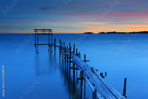 Beautiful sunset at old wooden bridge on sea coast © isarescheewin