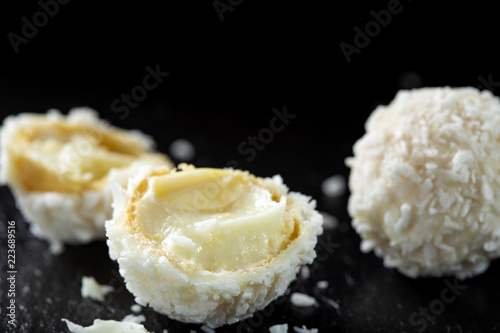 Close up of broken white candy with coconut flakes and white chocolate cream photo