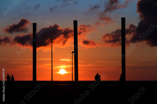 Beautiful sunset at the beach in Dieppe, Normandy, France, in summer with silhouettes on the boulevard
