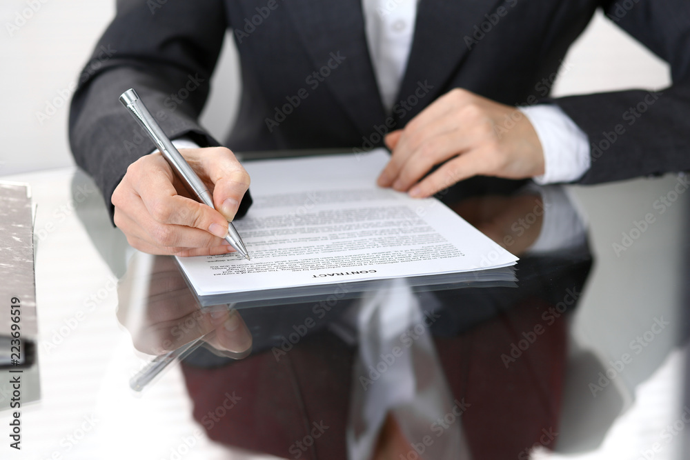 Close-up of female hands with pen over document of contact, business concept Close-up of female hands with pen over document of contact, business concept
