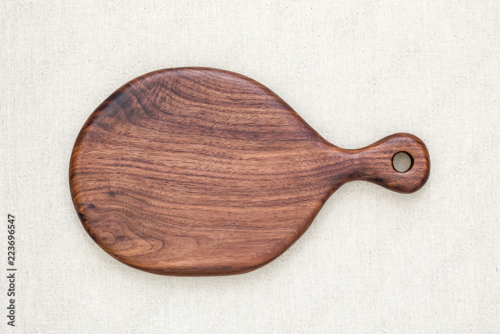 A handmade black walnut wooden chopping board on burlap A handmade black walnut wooden chopping board on burlap