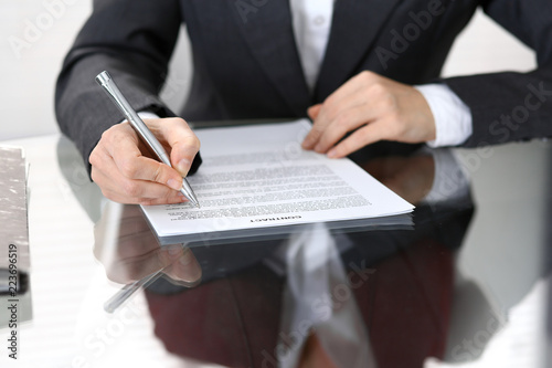 Close-up of female hands with pen over document of contact, business concept © rogerphoto