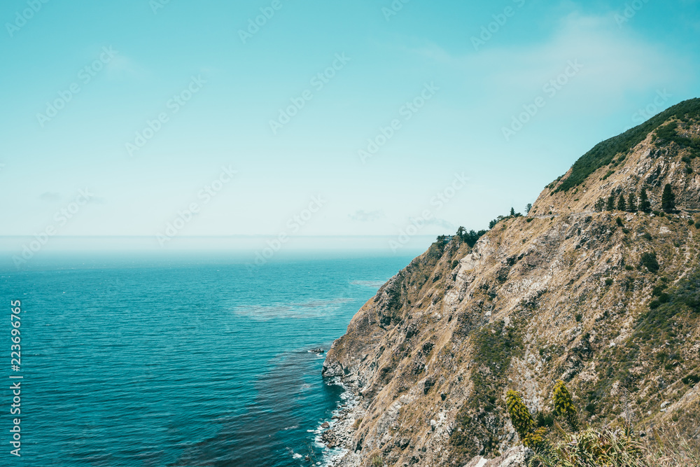 scenery of cliff surrounded by ocean and sky