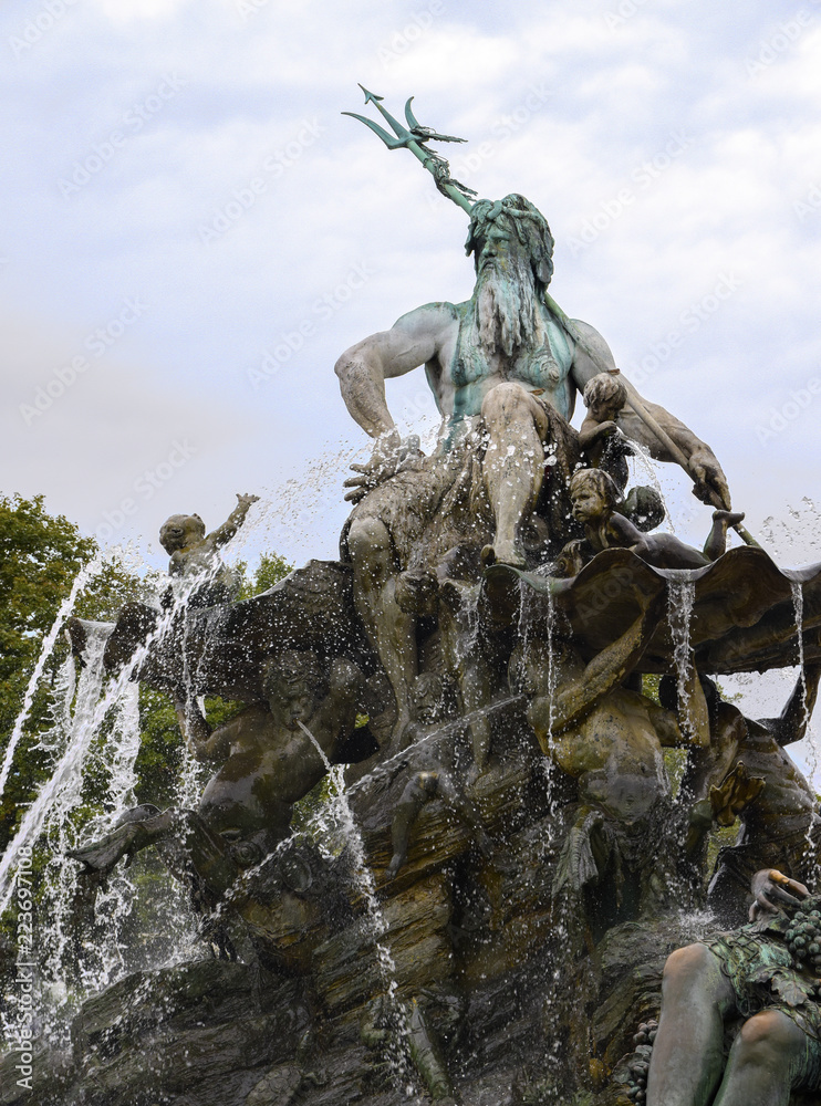 Part of the Neptune Fountain against a blue sky with clouds in the center of Berlin, district Mitte, Germany, copy space