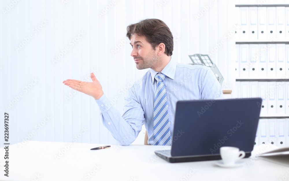 businessman sitting behind a Desk and pointing to copy space businessman sitting behind a Desk and pointing to copy space