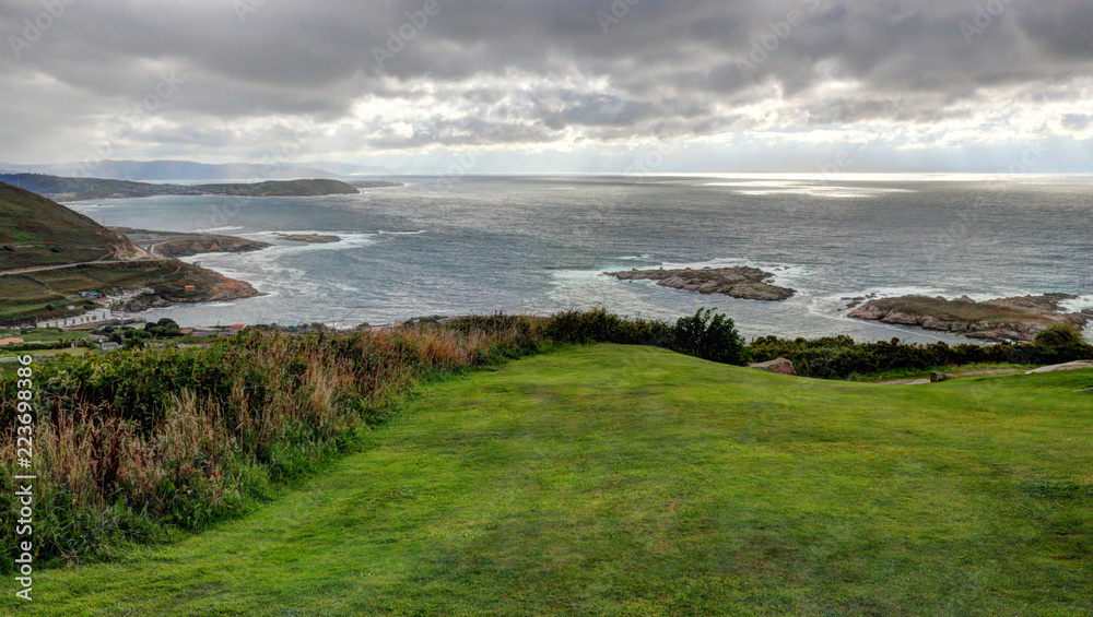 A landscape of a cloudy stormy sea and a grass lawn from Parque de Bens in Galicia capital city La Coruña