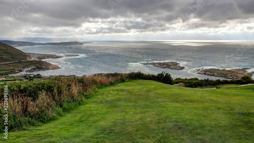 A landscape of a cloudy stormy sea and a grass lawn from Parque de Bens in Galicia capital city La Coruña