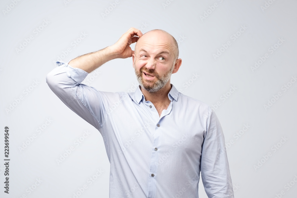 Mature european bearded young male dressed in casual white shirt trying to remember where he put the car keys. Mature european bearded young male dressed in casual white shirt trying to remember where he put the car keys.