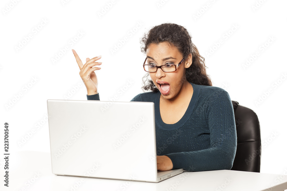 Young happy african woman using laptop surprised with an idea or question pointing finger with happy face, number one Young happy african woman using laptop surprised with an idea or question pointing finger with happy face, number one