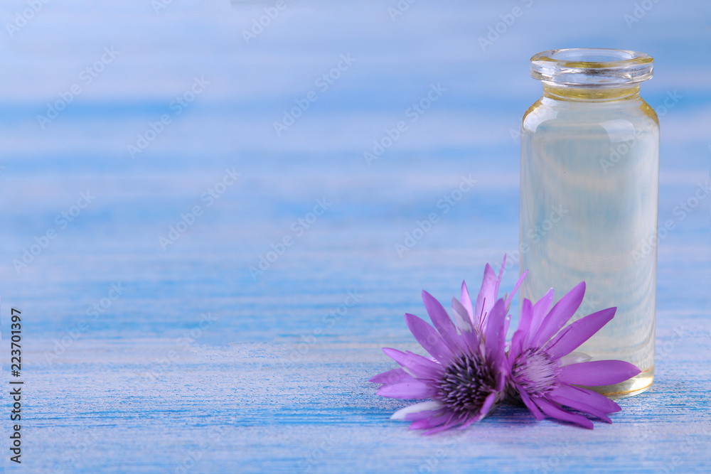 lilac field flowers with a bottle of essential oil on a blue wooden table with a place for writing lilac field flowers with a bottle of essential oil on a blue wooden table with a place for writing