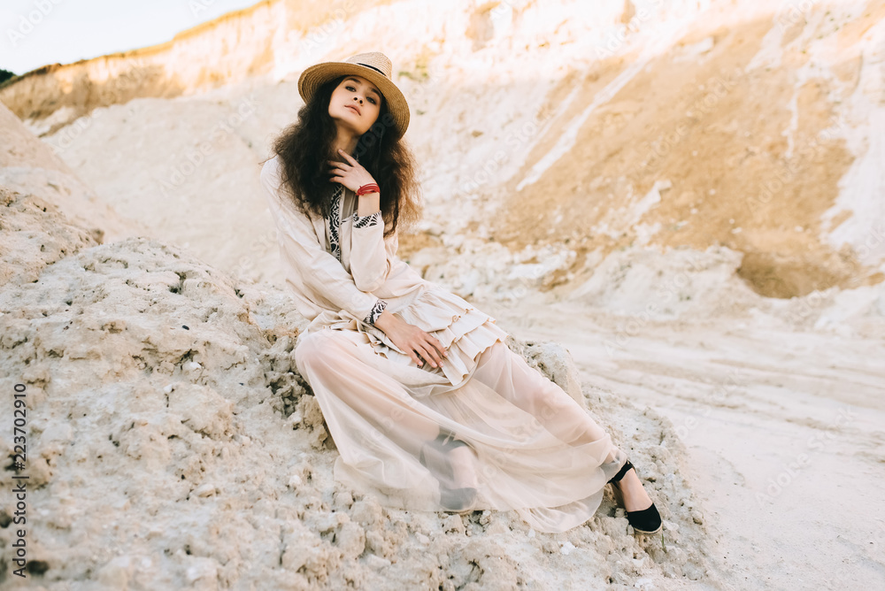 elegant girl posing in trendy dress and straw hat in sandy canyon elegant girl posing in trendy dress and straw hat in sandy canyon