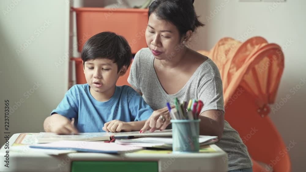 Children homework. Young mixed race boy doing homework in terrace at home. Reading book with his mother. Happy mood. Back to school concept. Children homework. Young mixed race boy doing homework in terrace at home. Reading book with his mother. Happy mood. Back to school concept.