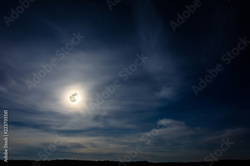 A wonderful full moon has descended over Ukrainian carpathians in blurry clouds