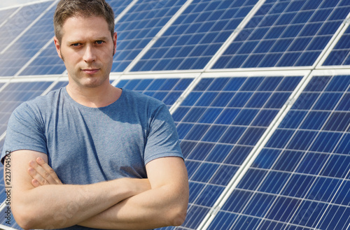 Man standing in front of solar panels. Renewable energy.