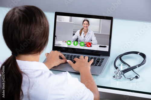 Doctor Video Conferencing With Female Colleague On Laptop © Andrey Popov