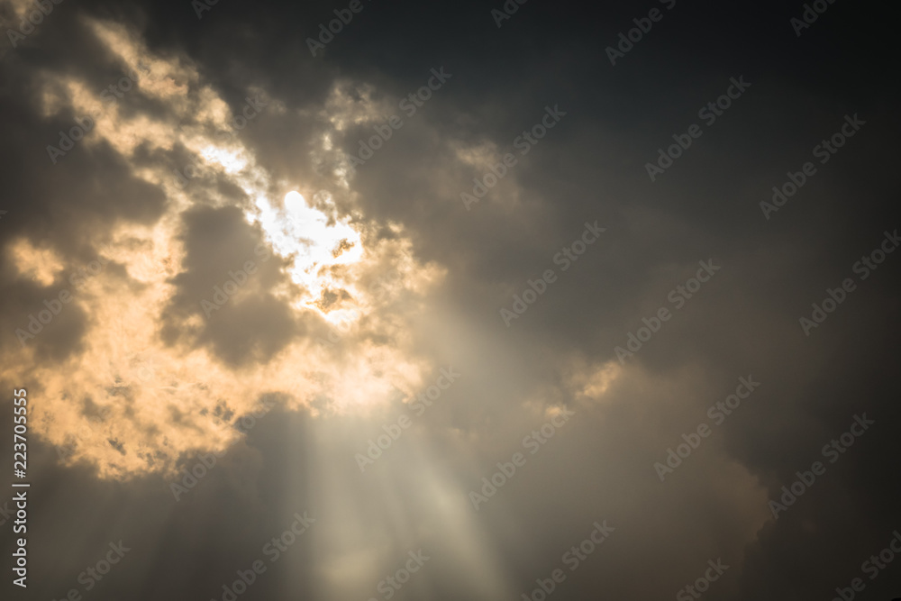 Obraz premium Sun beams light through dark clouds