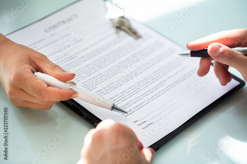 Close-up Of A Person's Hand Filling Contract Form
