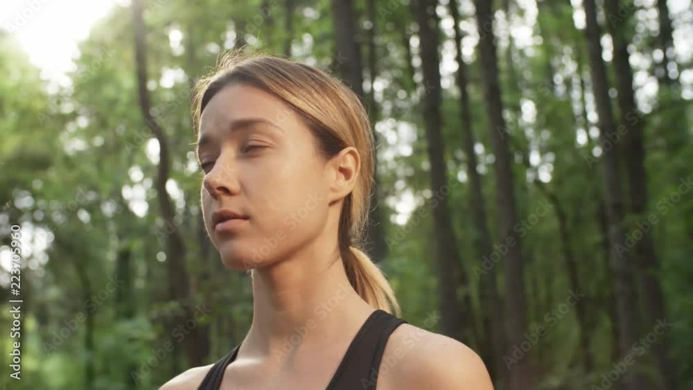 PAN shot of young woman daydreaming in forest on sunny summer day PAN shot of young woman daydreaming in forest on sunny summer day