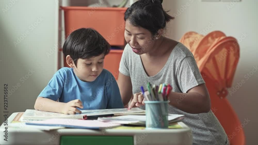 Children homework. Young mixed race boy doing homework in terrace at home. Reading book with his mother. Happy mood. Back to school concept. Children homework. Young mixed race boy doing homework in terrace at home. Reading book with his mother. Happy mood. Back to school concept.