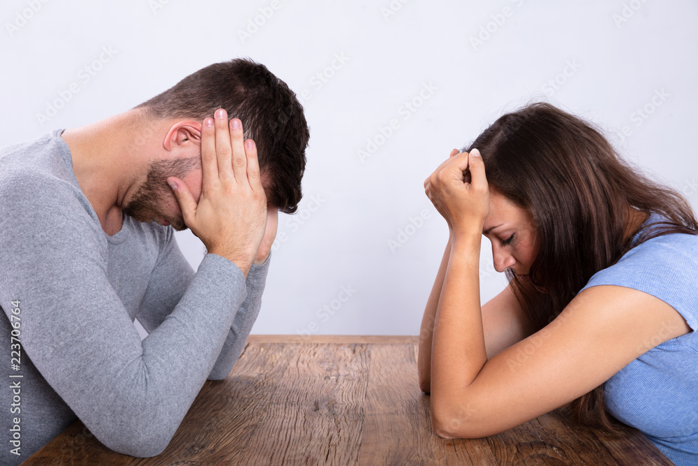 Depressed Couple Sitting Opposite Each Other Depressed Couple Sitting Opposite Each Other