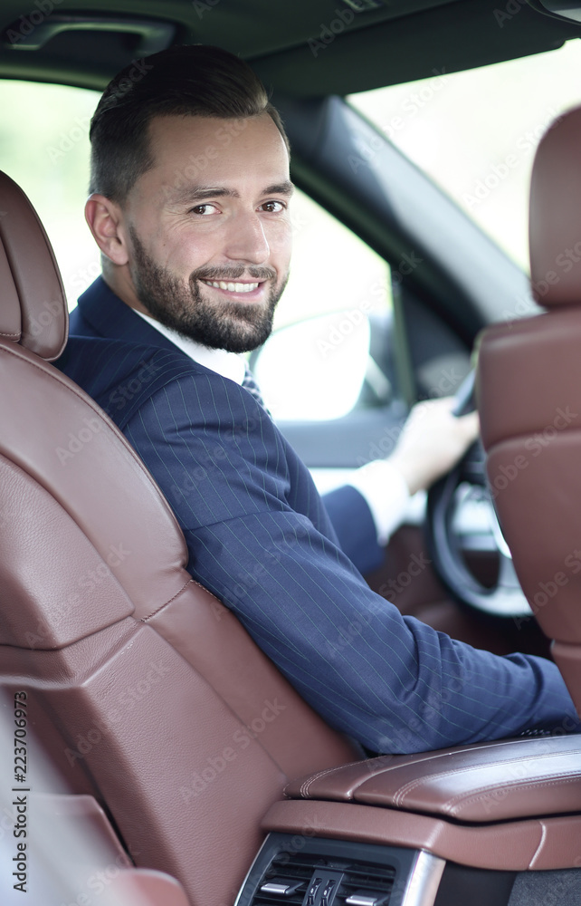 businessman sitting at the wheel of a car and looking at the camera businessman sitting at the wheel of a car and looking at the camera
