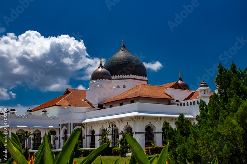 Obraz na płótnie A white mosque with dark dome roof caps and a tile rooftop in Malaysaia w salonie