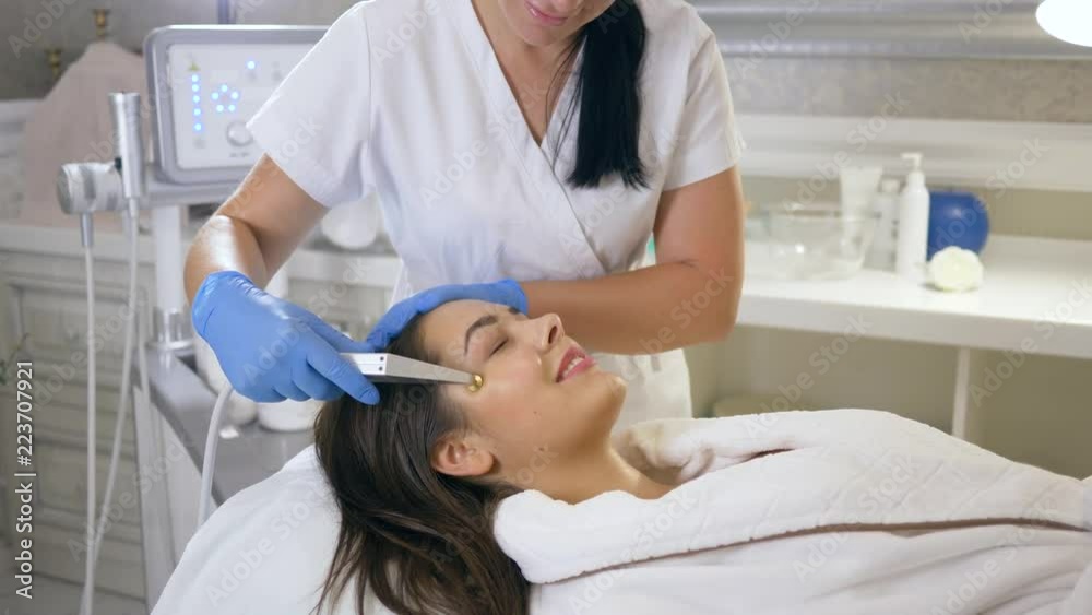 care skin, happy client female on rejuvenating procedures for face with help of pulsating oxygen pressure in Beauty parlor close-up