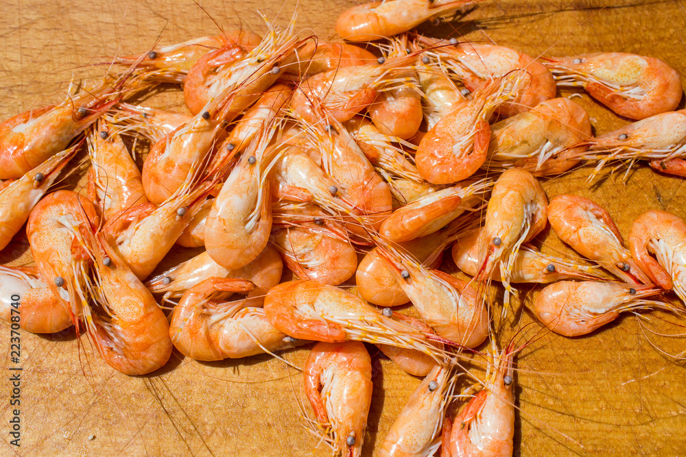 boiled red shrimps on wooden tray, seafood background