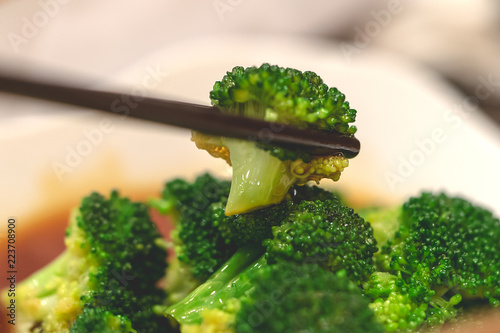 Chopstick picking up Chinese style fried broccoli
