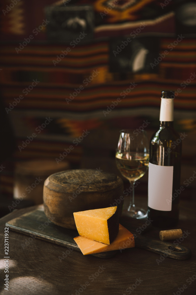 delicacy cheese with white wine on rustic wooden table