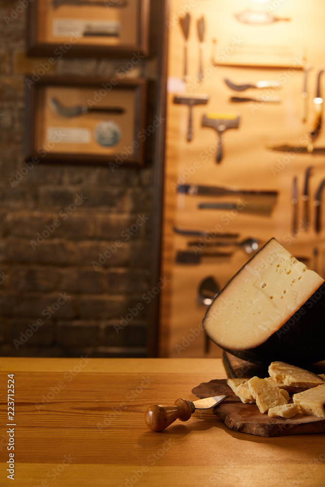 close-up shot of sliced cheese with knife on wooden cutting board close-up shot of sliced cheese with knife on wooden cutting board