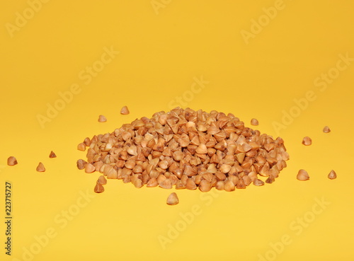 Buckwheat grains close-up isolated on a yellow background