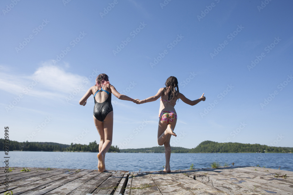 Preteen teens playing and jumping off a dock. Preteen teens playing and jumping off a dock.